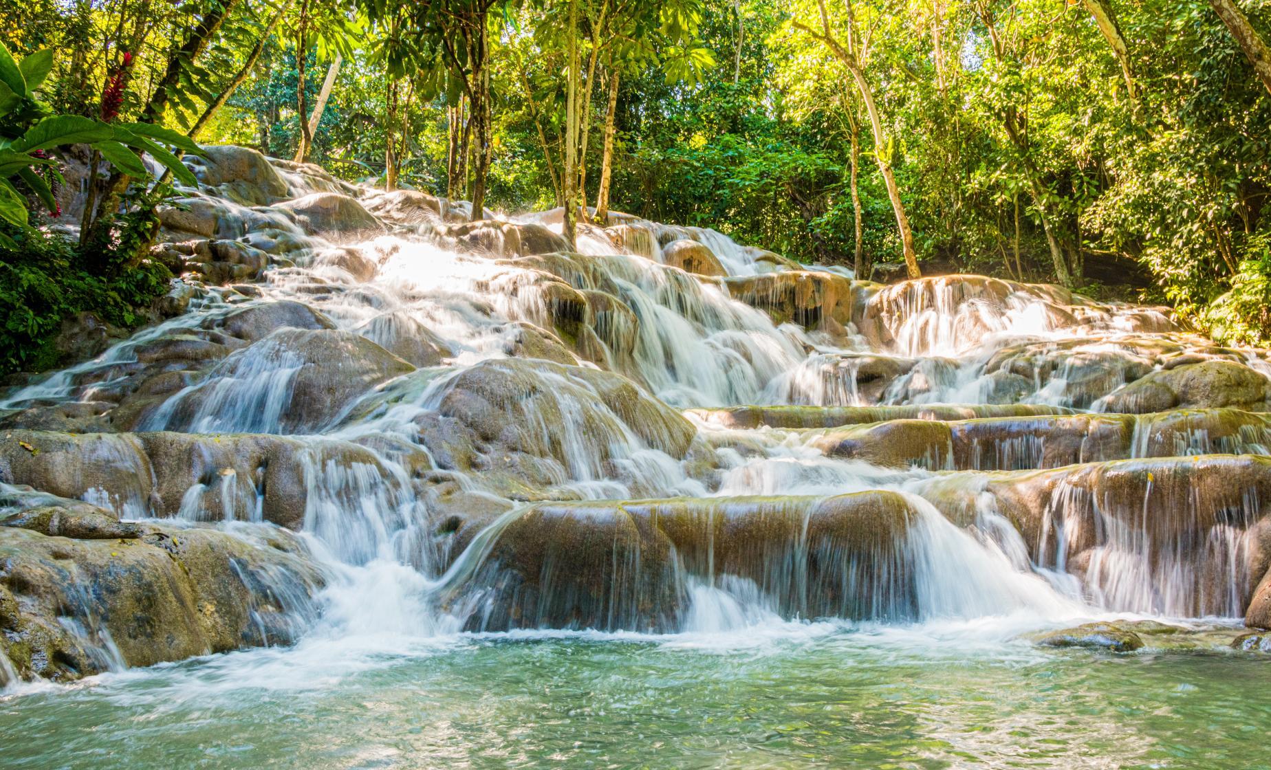 Travellers climbing the terraced cascades of Dunn's River Falls, Jamaica